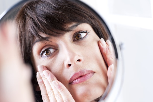 Woman holding hands to cheeks