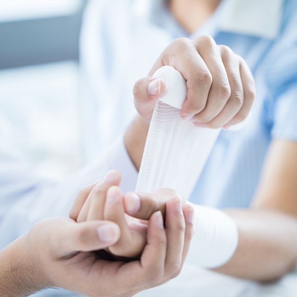 Doctor wrapping wrist with bandages