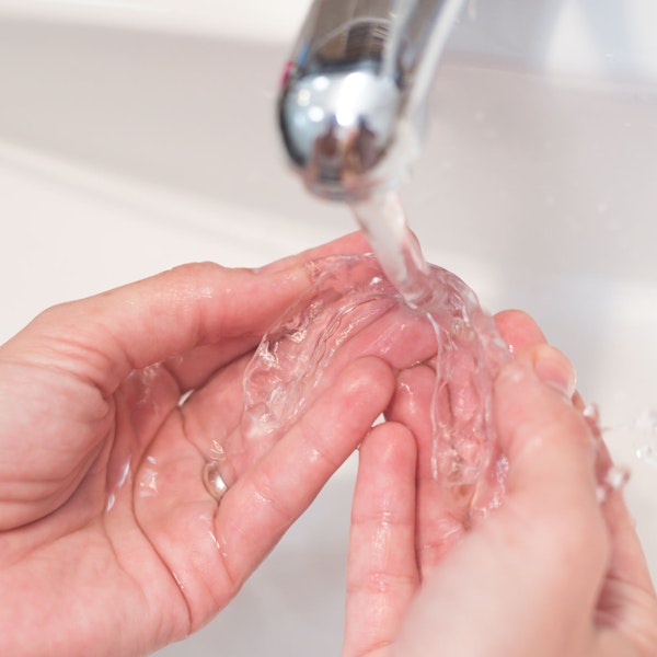 Person washing Invisalign aligner in water