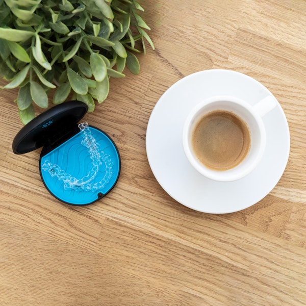 Invisalign next to a cup of coffee