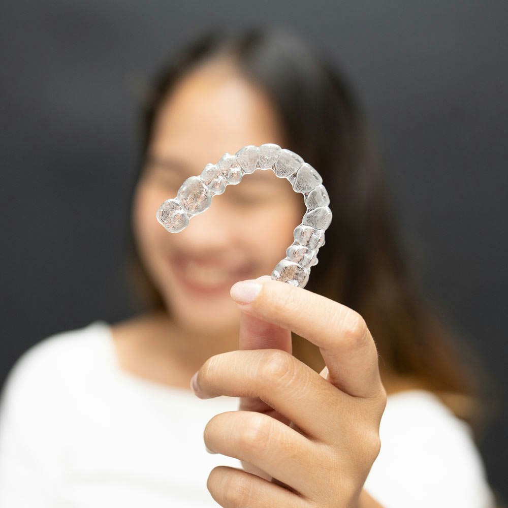 woman holding suresmile aligner