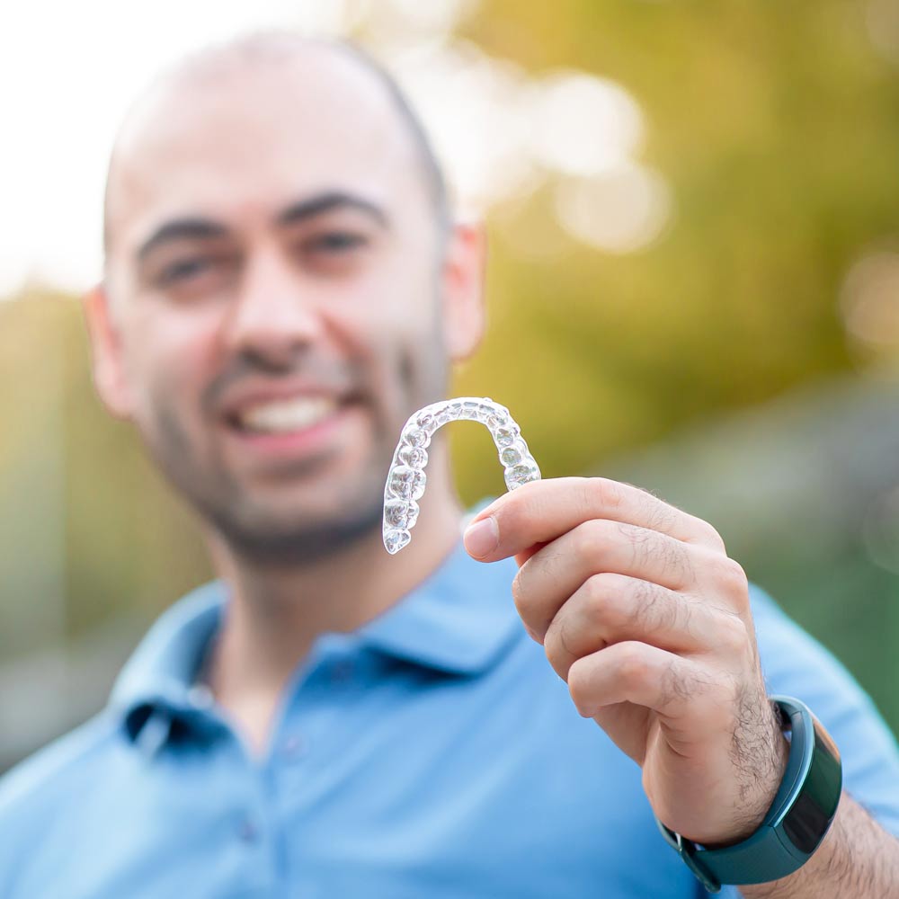 patient holding up an Invisalign tray