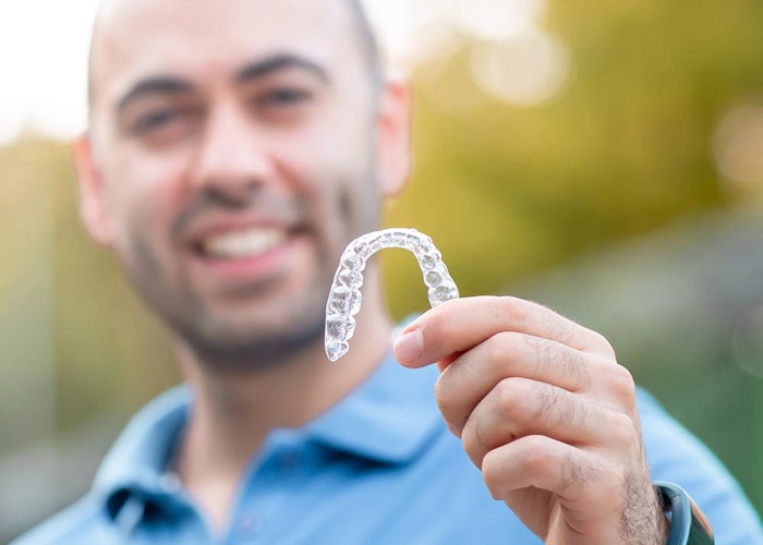 Man holding clear aligner tray