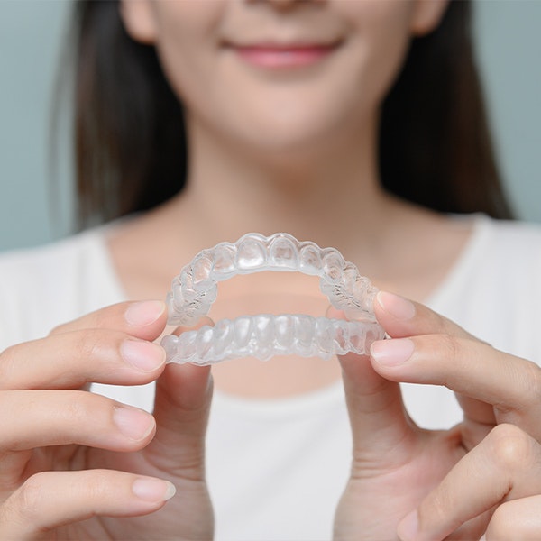 Girl holding an Invisalign aligner