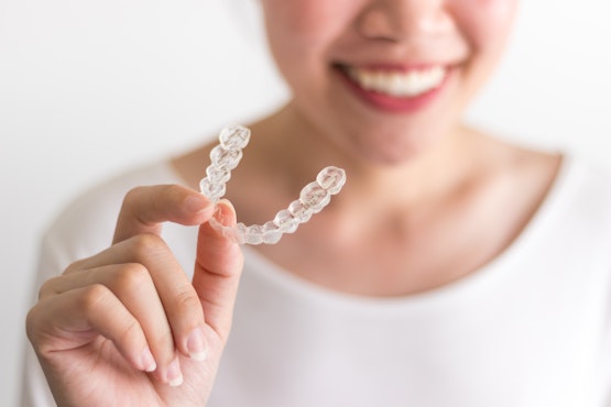 Woman holding a clear aligner