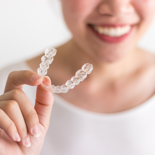 Woman holding Invisalign retainer