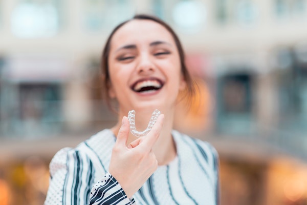 Woman holding clear aligner