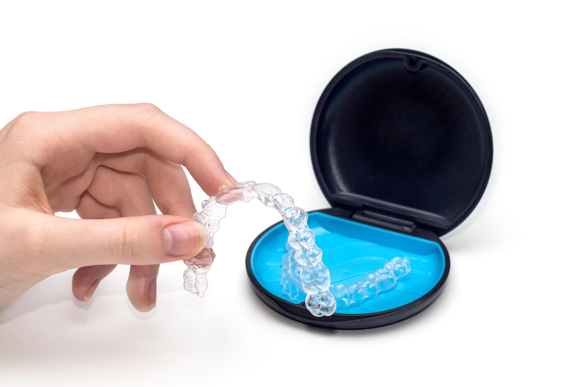 Person holding Invisalign in front of Invisalign container