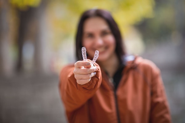 Woman holding clear aligner