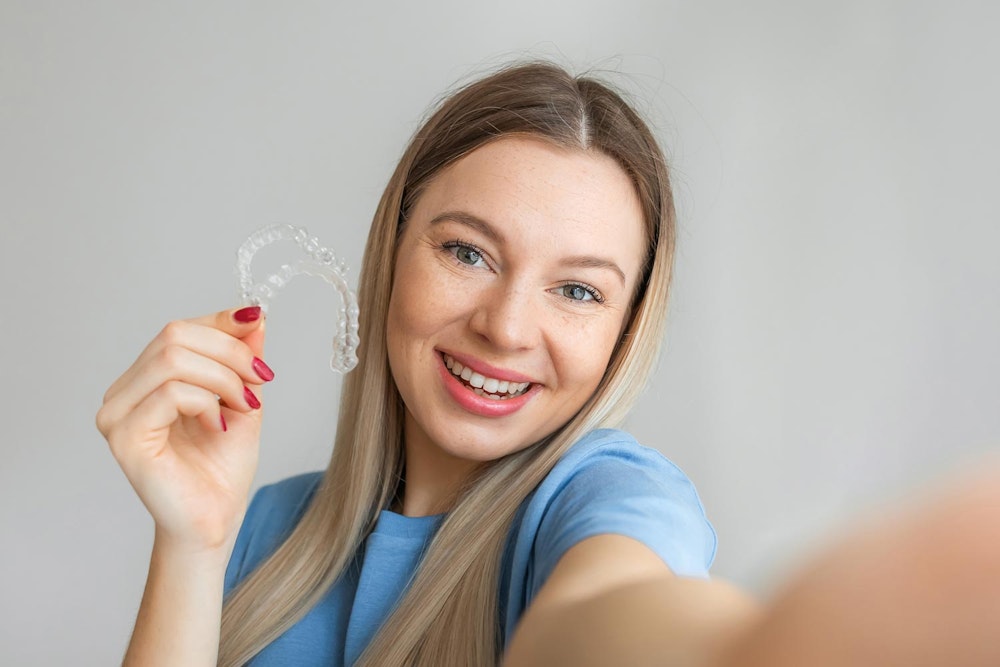 Smiling woman taking a selfie with invisaligns