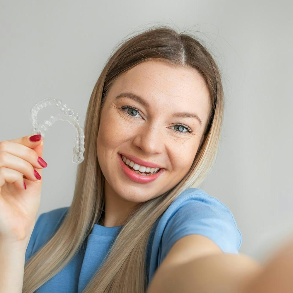 Smiling woman taking a selfie with invisaligns