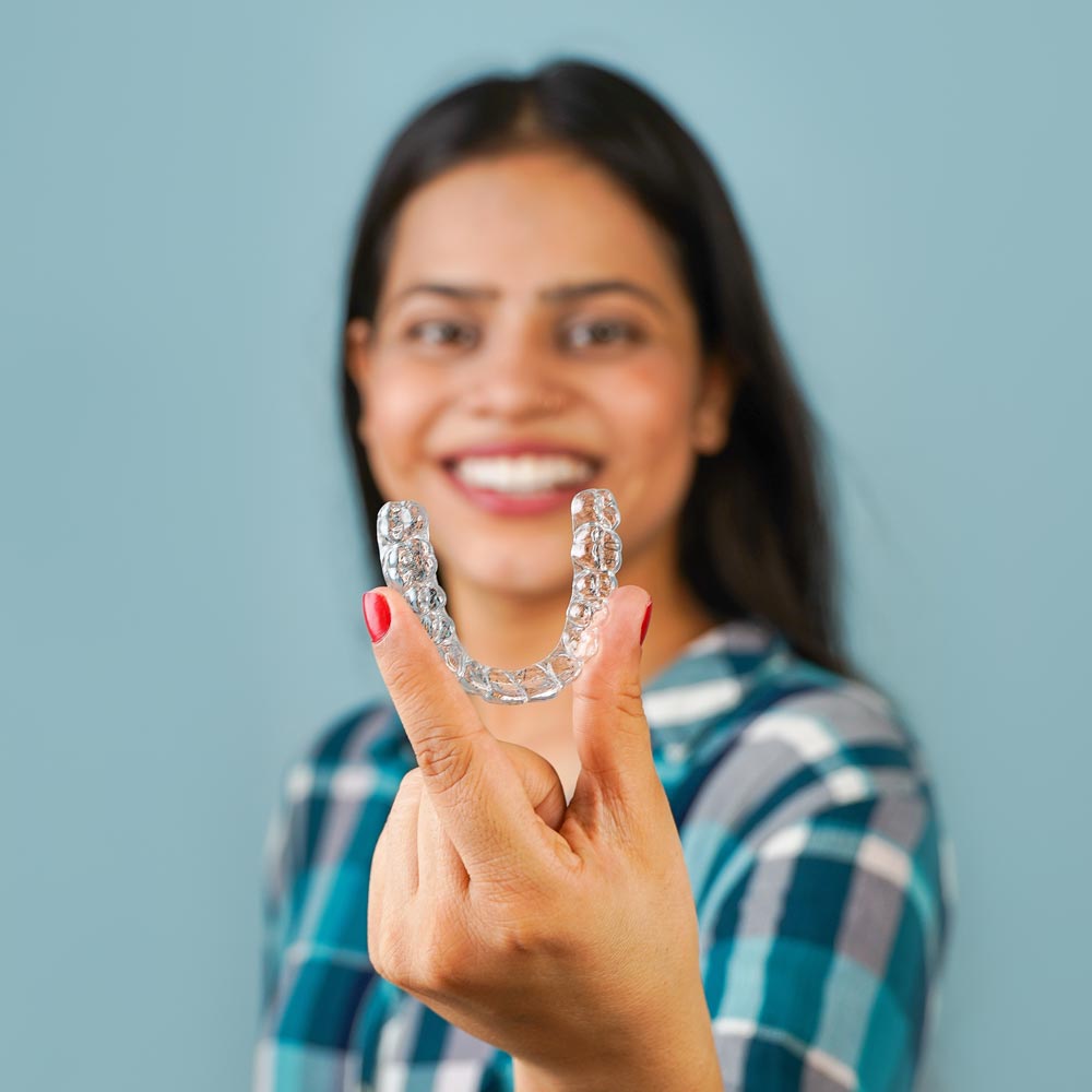woman holding clear aligner