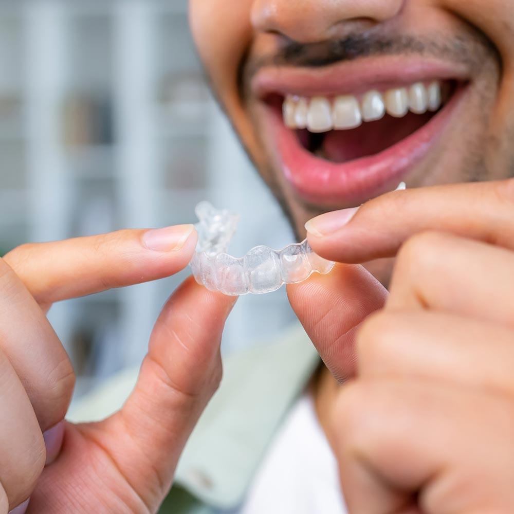 Teenager putting on Invisalign