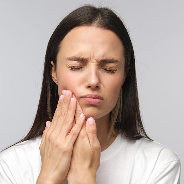 Woman holding jaw in pain