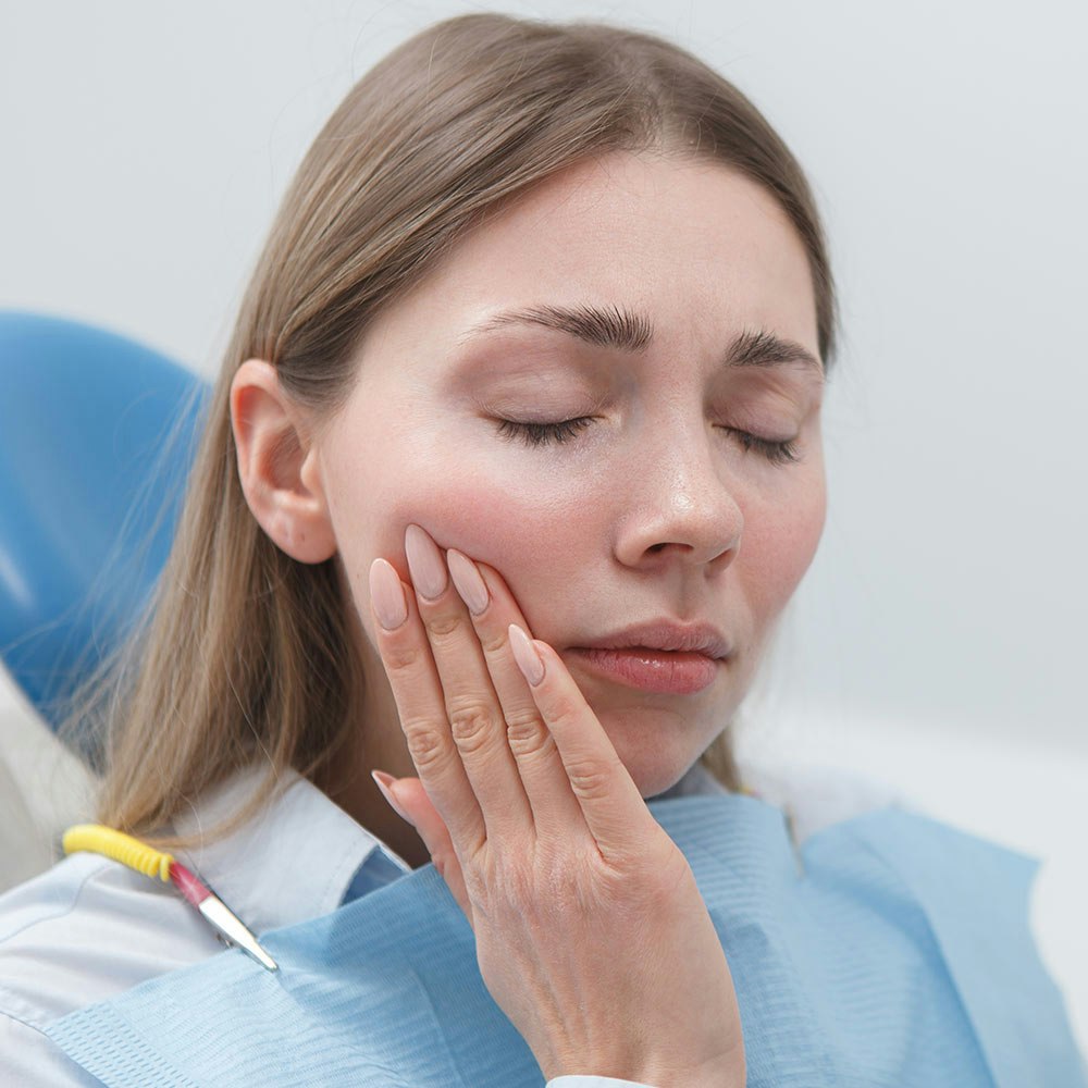 Woman at the dentists holding jaw in pain