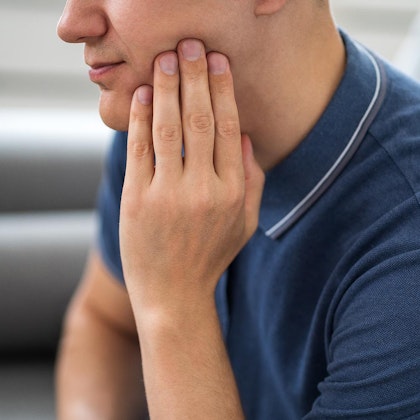 Man holding hand to jaw