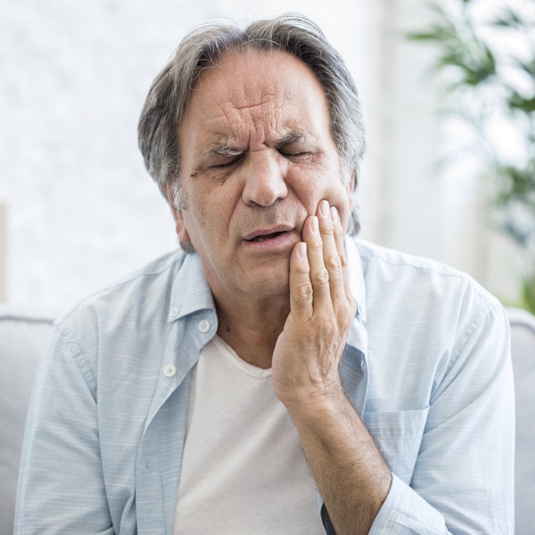Mature man holding jaw in pain