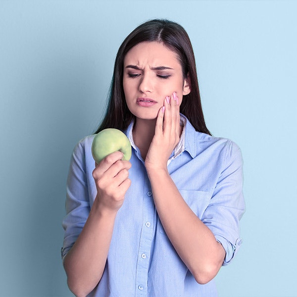 woman holds apple and jaw