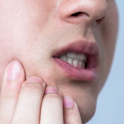 Man gripping jaw in pain