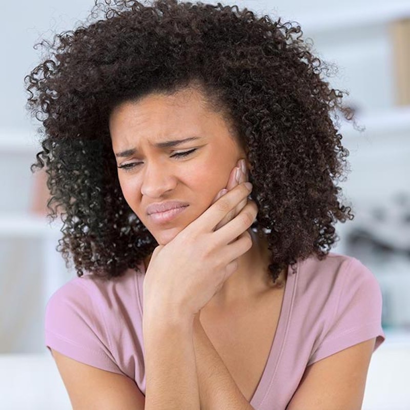 Lady holding jaw in pain