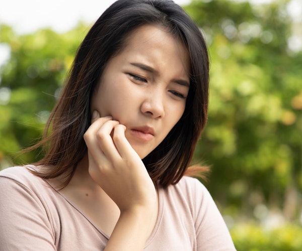 Woman holding jaw in pain