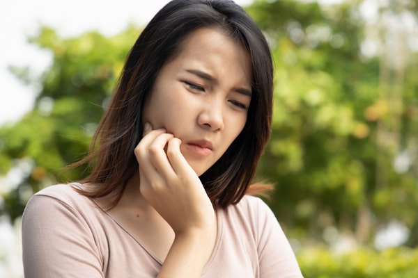 Woman holding jaw in pain