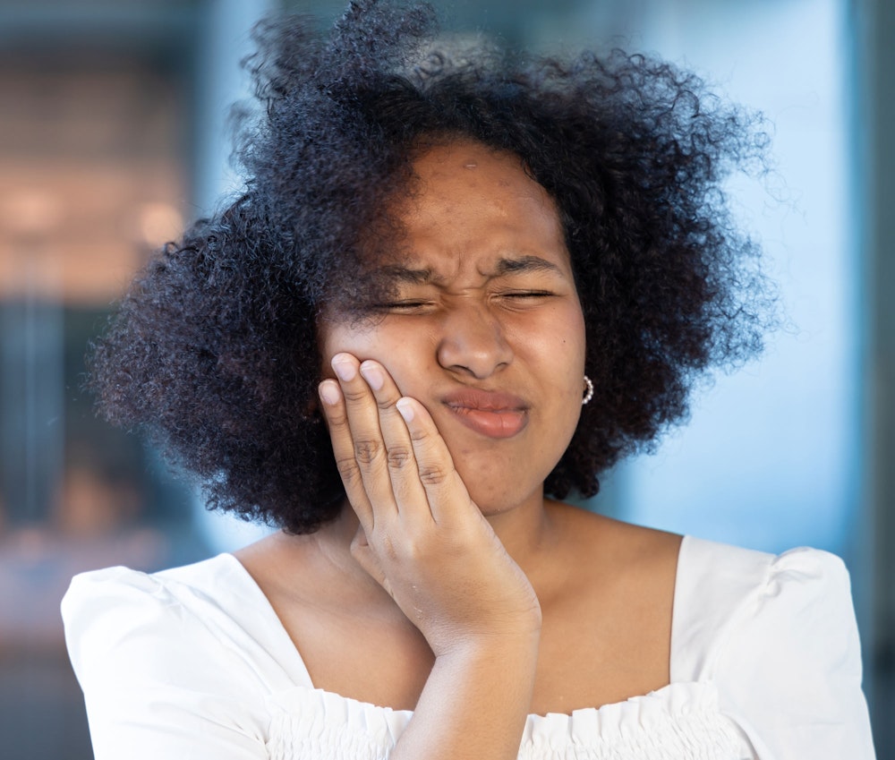 Woman holding jaw in pain