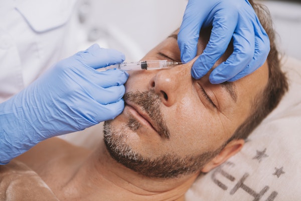 Man receiving injection for rhinoplasty