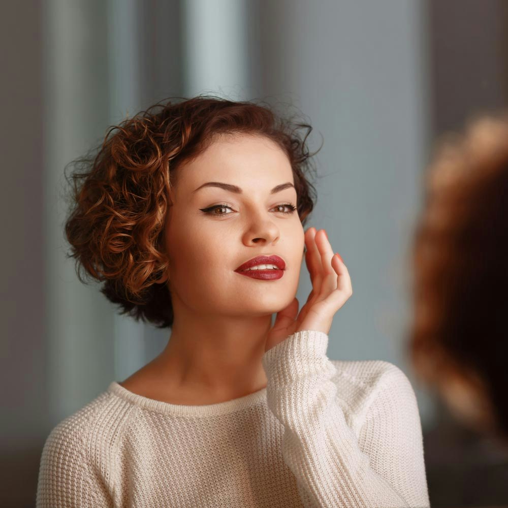 woman examining her face