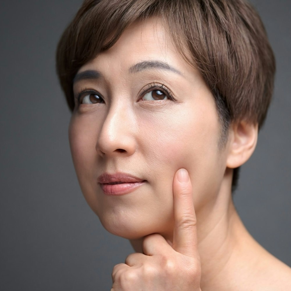 Middle aged woman touching cheek