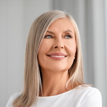 Mature woman looking to the side and smiling with facelift