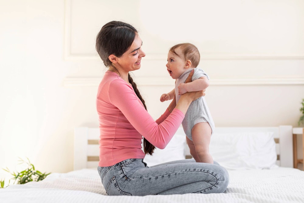 Side profile of mother holding baby smiling