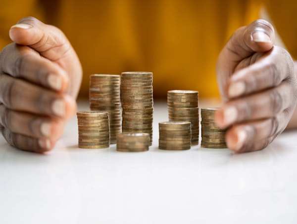 Woman guarding stacks of coins