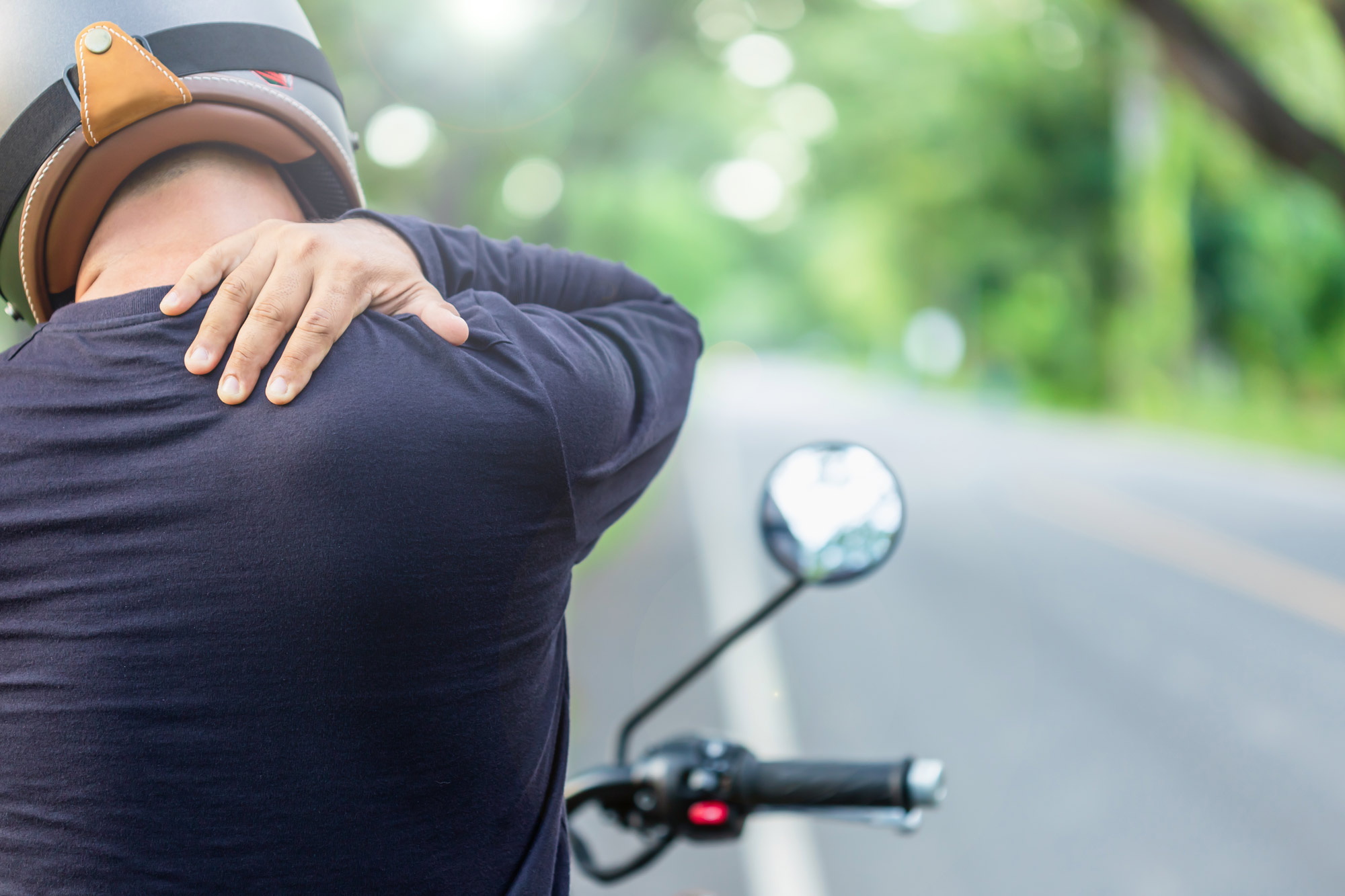 Motorcyclist holding neck in pain
