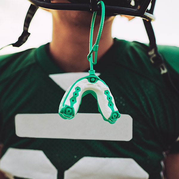 Athlete with mouthguard attached to helmet