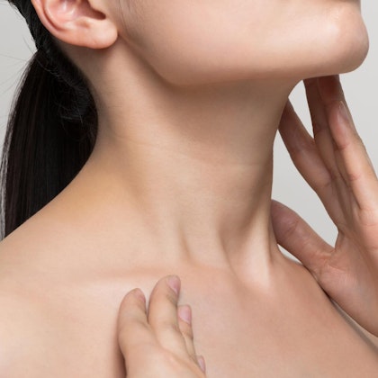Close up of woman touching chin and neck