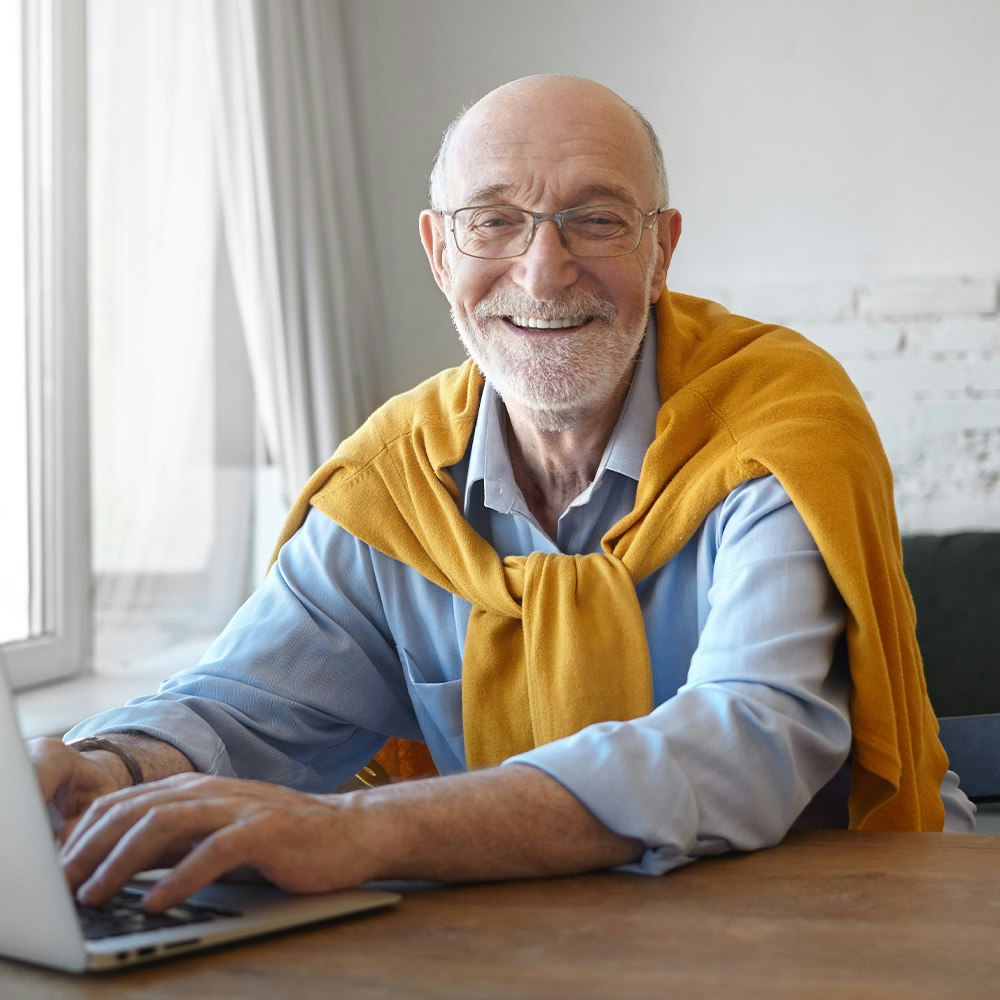 Smiling older man on laptop