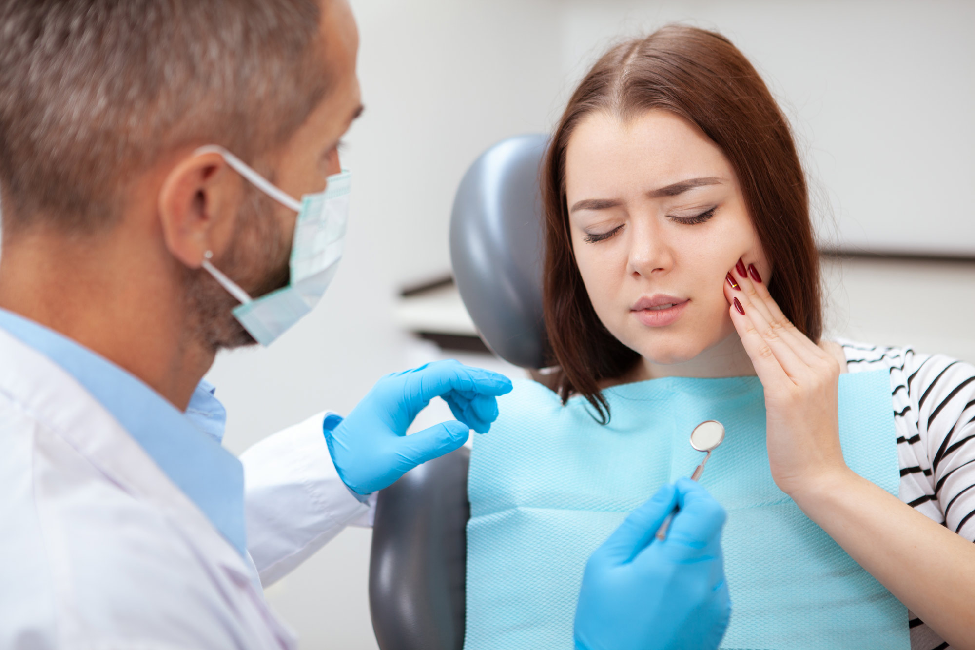 Woman with tooth pain at the dentist office