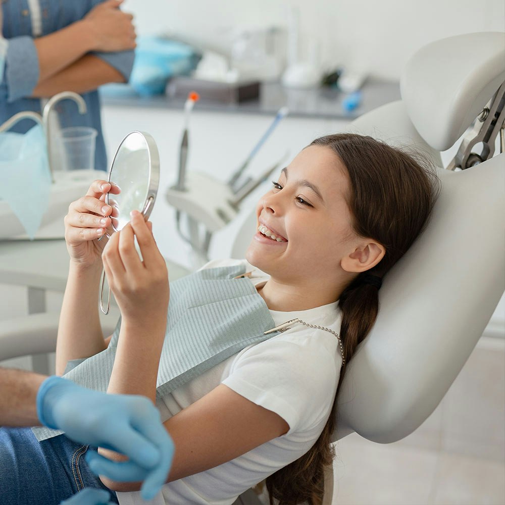 Little girl looking at her teeth in a mirror
