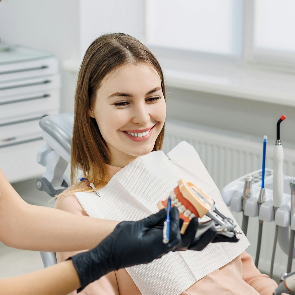 Patient learning about teeth from dentist and teeth model