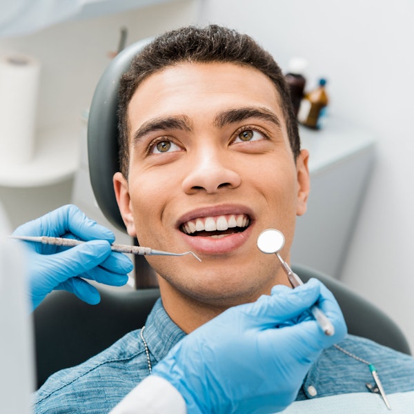 Young man getting his teeth checked by the dentist