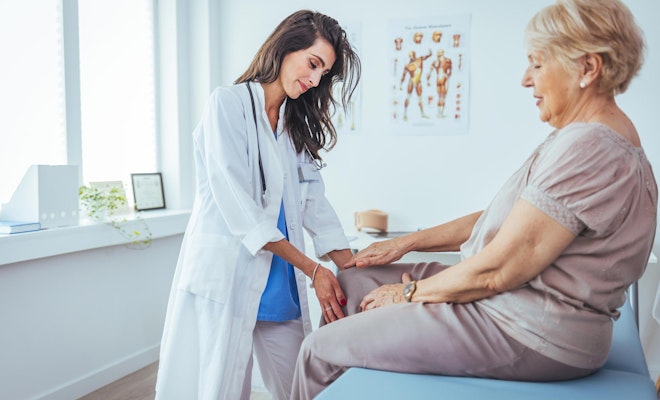 Doctor checking patient's knee