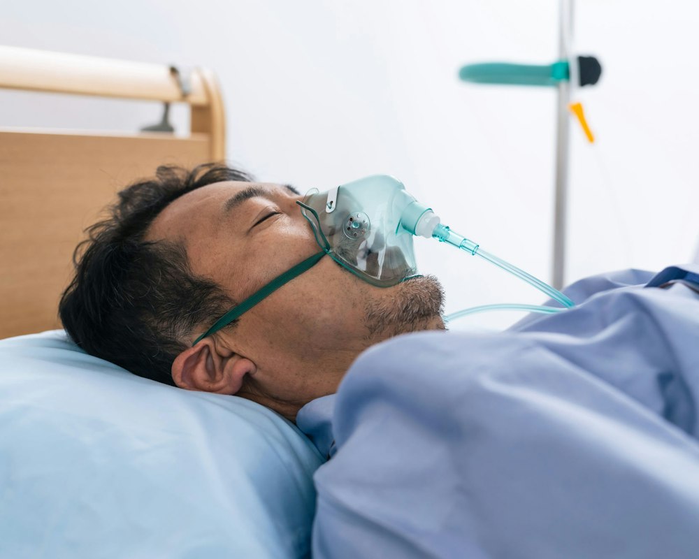 Man receiving oxygen in hospital bed