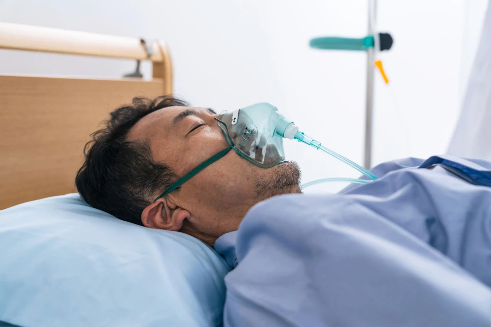 Man receiving oxygen in hospital bed