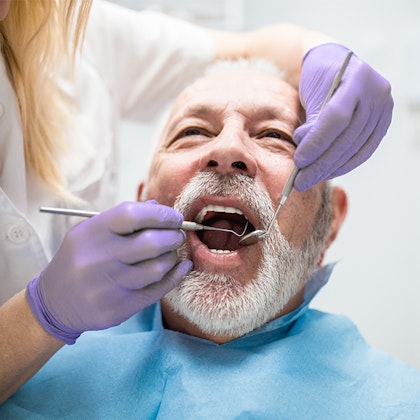 Dentist working on older patient
