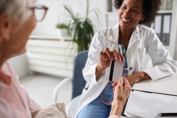 Woman giving doctor a debit card