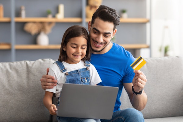 Father and young daughter buying something online