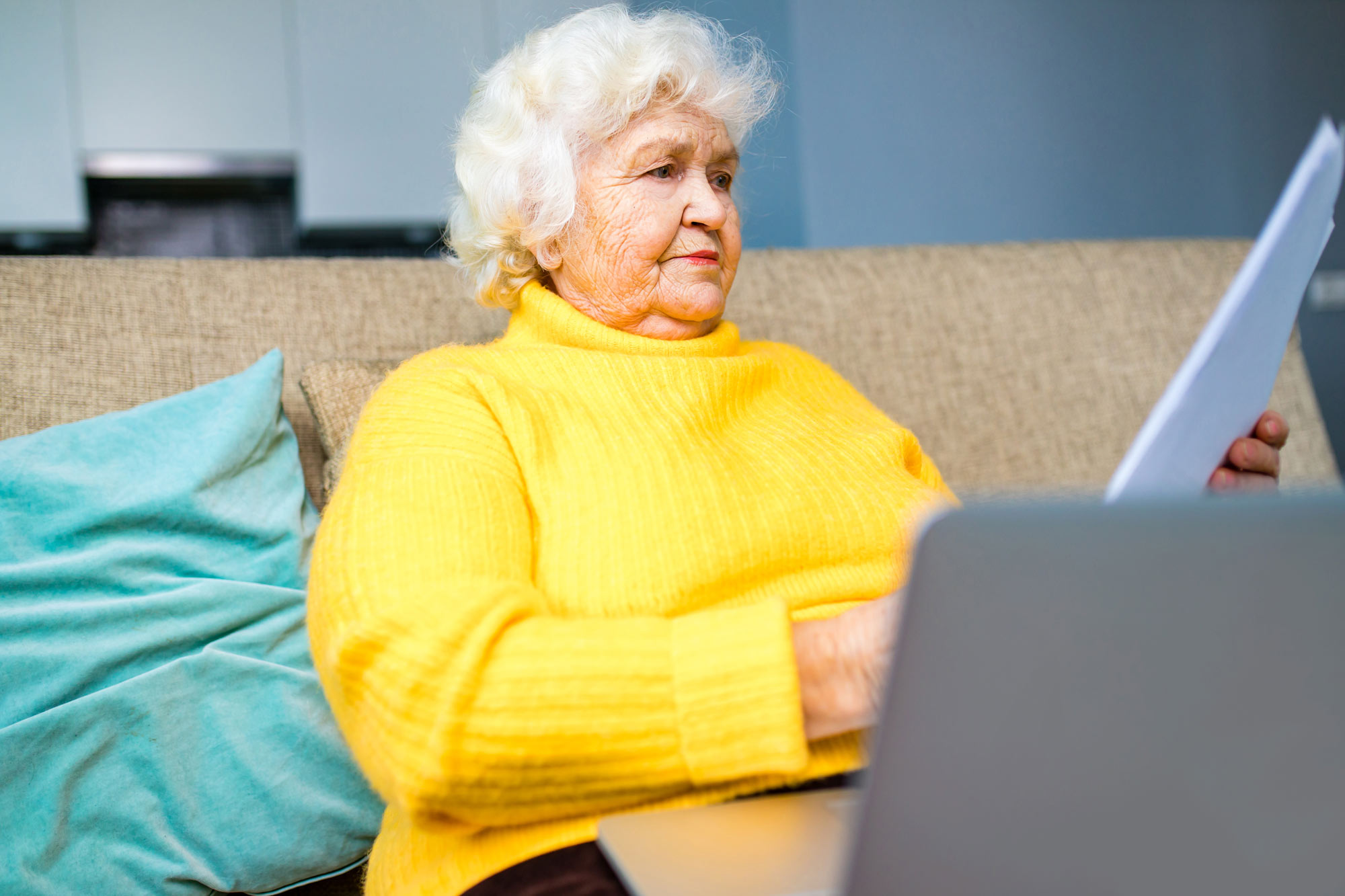Elderly woman struggling to read papers