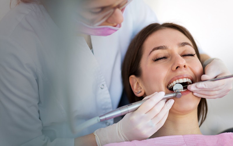 Dentist performing dental exam on woman