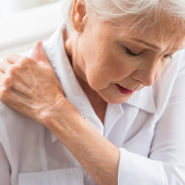 Mature woman holding shoulder in pain